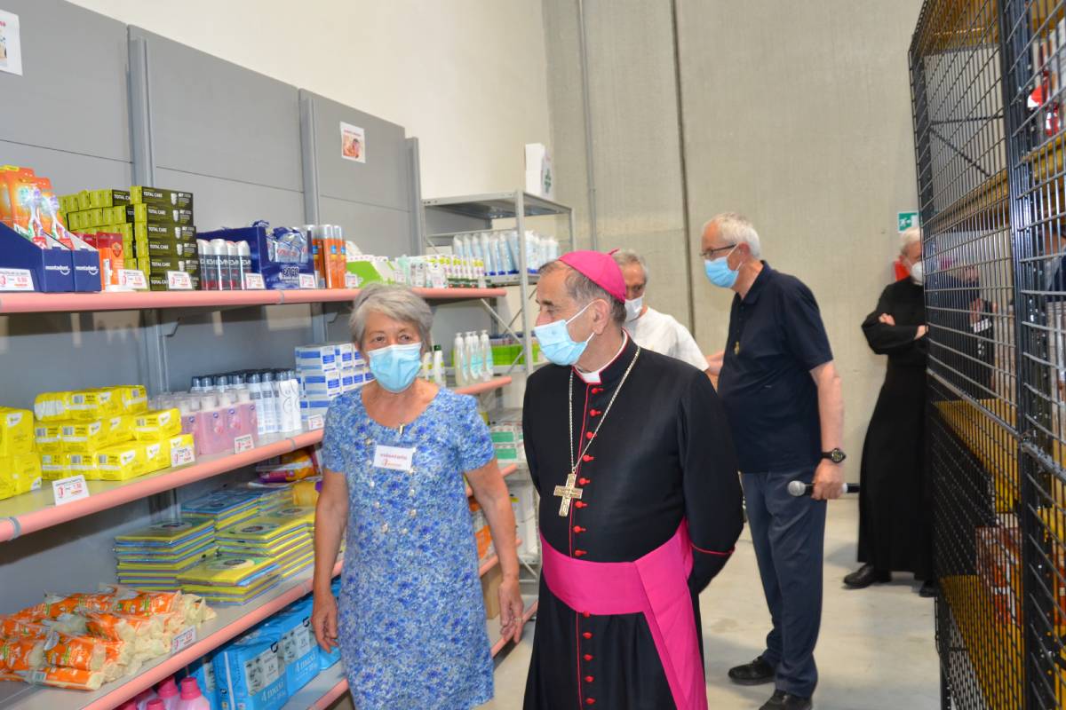 L'arcivescovo Delpini accompagnato da una volontaria in occasione dell'inaugurazione dell'Emporio