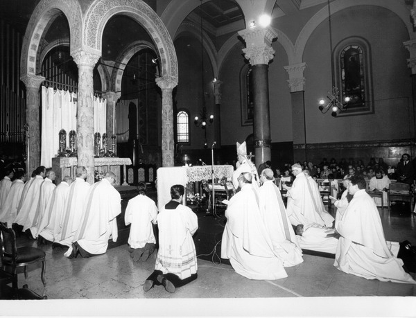durante la cerimonia mons. giacomo biffi sta steso sui gradini dell'altare tra vescovi che pregano in ginocchio