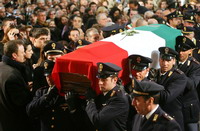 Italian police officers carry the coffin, covered in the Italian flag, of Filippo Raciti, the policeman killed Friday when a home made bomb was thrown into his car, 05 February 2007, during the funeral mass at Catania Cathedral. About 1,000 people were inside the cathedral and several thousand more waited outside, highlighting the nationwide shock caused by the policeman's death.  AFP PHOTO / Marcello PATERNOSTRO