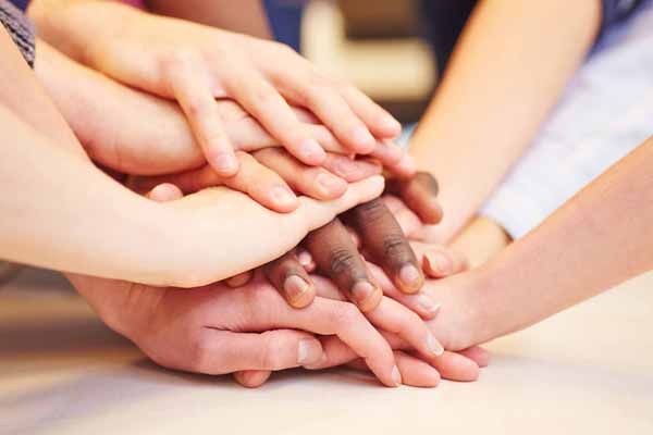 Motivation und Zusammenhalt durch viele gestapelte Hände in der Schule