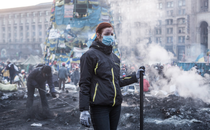 KIEV, UKRAINE - FEBRUARY 20: A woman clears ashes and debris with other anti-government protesters from a newly-occupied portion of Independence Square on February 20, 2014 in Kiev, Ukraine. Dozens of protesters were reportedly been killed after violence flared again between police and anti-government protesters, who are calling to oust President Viktor Yanukovych over corruption and an abandoned trade agreement with the European Union.  (Photo by Brendan Hoffman/Getty Images)