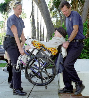 Santa Monica firefighters Sarah Billman, left, and David Saxby assist Lillian Kaufman to her third-floor apartment after the power was shut off to her apartment building, rendering the elevator inoperable due to rolling blackouts, Monday, March 19, 2001, in Santa Monica, Calif. (AP Photo/Dan Steinberg)