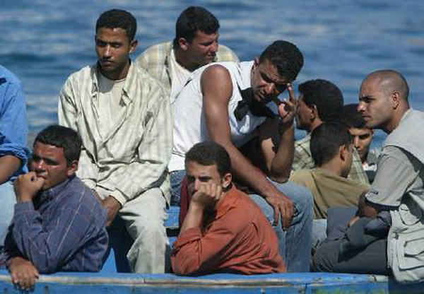 Immigrati irregolari su una barca a Lampedusa. REUTERS/Tony Gentile