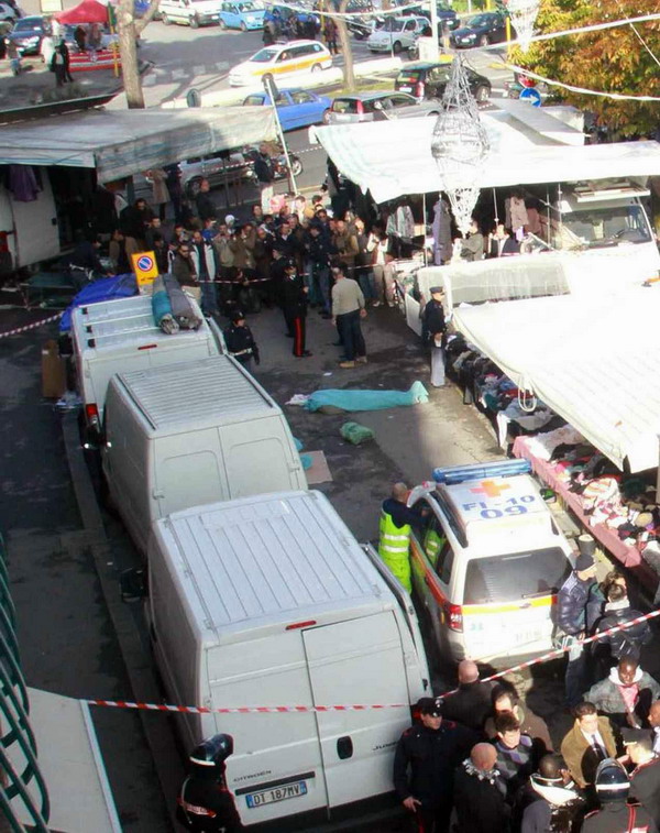 Policemen stand by the bodies of two Senegalese vendors who were killed on a market on December 13, 2011 in Florence. An Italian far-right militant Tuesday killed two Senegalese vendors and wounded three people in a shooting spree in broad daylight in Florence after which he was found shot dead.  AFP PHOTO / STR