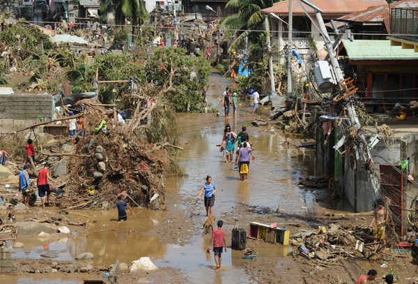 Debris are scattered near destroyed houses in Cagayan de Oroon December18, 2011, a day after Typhoon Washi wrought havoc in the city. Philippine rescuers strived with mud, fatigue and the stench of death December 18 to help dazed survivors of devastating flash floods that have killed about 500 people.    AFP PHOTO/TED ALJIBE