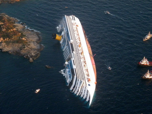 RESTRICTED TO EDITORIAL USE MANDATORY CREDIT "AFP PHOTO/ ITALIAN GUARDIA DE FINANZA" NO MARKETING NO ADVERTISING CAMPAIGNS - DISTRIBUTED AS A SERVICE TO CLIENTSA handout aerial view taken and released on January 14, 2012 by Italian Guardia de Finanza shows the Costa Concordia, after the cruise ship ran aground and keeled over off the Isola del Giglio, on late January 13. Three people died and several were missing after the ship with more than 4,000 people on board ran aground sparking chaos as passengers scrambled to get off. The ship was on a cruise in the Mediterranean, leaving from Savona with planned stops in Civitavecchia, Palermo, Cagliari, Palma, Barcelona and Marseille," the company said.      AFP PHOTO/ HO/ ITALIAN GUARDIA DE FINANZA