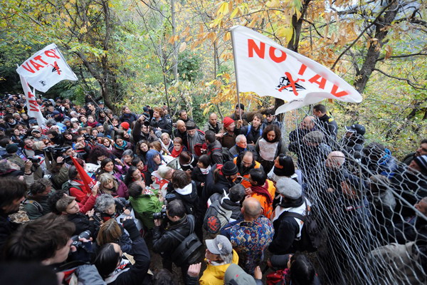 Demonstrators of the "No Tav" (No to High-Speed Trains) movement try to pass a police fence on October 23, 2011 in Chiomonte, to reach the construction zone of the future tunnel. The protest organised by the No Tav (No to High-Speed Trains) movement and residents of the Susa Valley have fiercely opposed the plan, saying the construction of tunnels would damage the environment. France and Italy signed a deal in 2001 on building a line through the area, a strategic link in the European network that would cut travel time between Milan and Paris from seven to four hours. AFP PHOTO/ OLIVIER MORIN