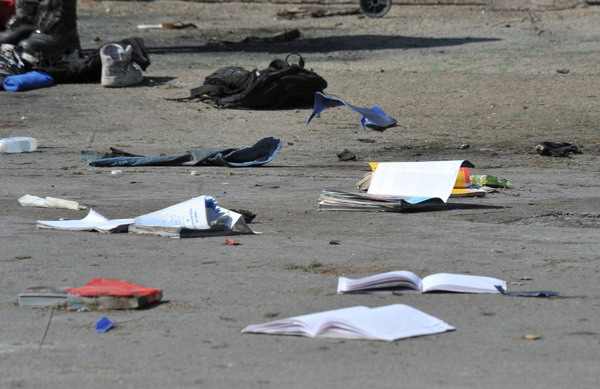 School books lie on the ground after a blast near a school in Brindisi on May 19, 2012.  A 16-year-old girl died Saturday after a powerful bomb blast outside their school in the southern Italian city of Brindisi, with another seven injured, one critically. No one has claimed responsibility for the blast caused by gas canisters hidden in a container or backpacks placed near a wall of the school grounds, according to initial indications.  AFP PHOTO / DONATO FASANO