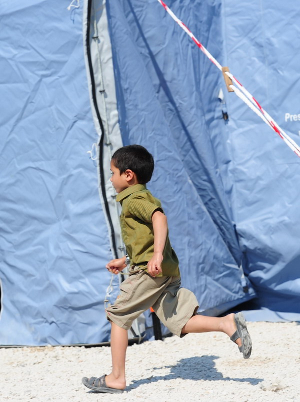 A chilkd runs in a temprorary emergency camp after an earthquake on May 29, 2012 in Mirandola. A strong earthquake rocked northeastern Italy Tuesday, killing at least 15 people, just days after another quake in the same region wrought death and destruction. AFP PHOTO / OLIVIER MORIN