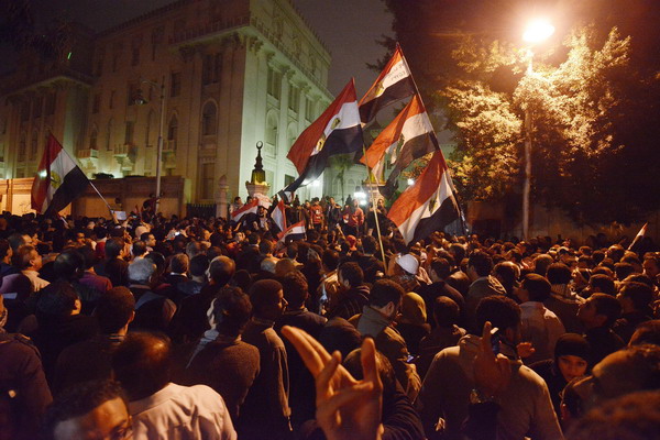 Egyptian protesters demonstrate outside of the presidential palace in Cairo on December 4, 2012, against President Mohamed Morsi's decree widening his powers. Tens of thousands of demonstrators encircled the presidential palace after riot police failed to keep them at bay with tear gas, in a growing crisis over President Morsi. AFP PHOTO/GIANLUIGI GUERCIA