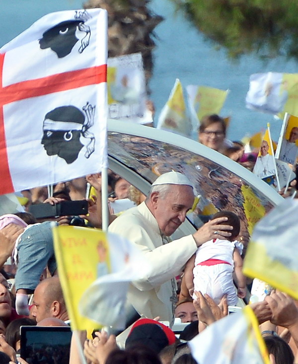 Pope Francis arrives to celebrate a mass in Cagliari on September 22, 2013. The pope is on a one-day pastoral visit to Sardinia to meet workers, business representatives, prisoners, the poor, young people, leading representatives from the world of culture and the islands Catholic bishops. The pontiff wanted to visit the Marian shrine of Bonaria ("Good air") because it gave his hometown of Buenos Aires its name. AFP PHOTO / ALBERTO PIZZOLI