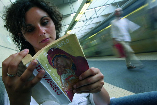 ROMA FERMATA DELLA METRO UNA GIOVANE LEGGE IL VANGELO