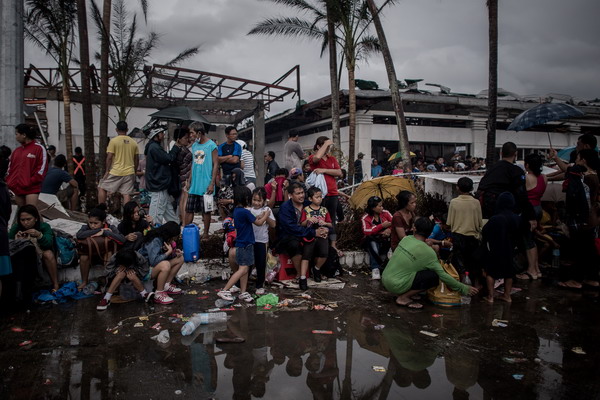 Typhoon victims wait to be evacuated at the airport in Tacloban, on the eastern island of Leyte on November 12, 2013 after Super Typhoon Haiyan swept over the Philippines. The typhoon that destroyed entire towns across the Philippines is believed to have killed more than 10,000 people, which would make it the country's deadliest recorded natural disaster.   AFP PHOTO/Philippe Lopez