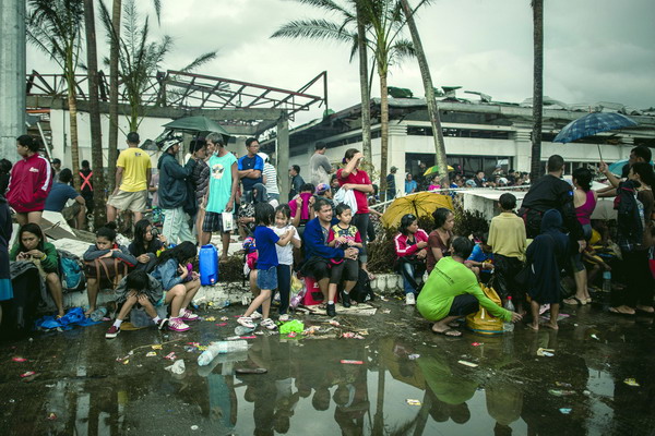 Typhoon victims wait to be evacuated at the airport in Tacloban, on the eastern island of Leyte on November 12, 2013 after Super Typhoon Haiyan swept over the Philippines. The typhoon that destroyed entire towns across the Philippines is believed to have killed more than 10,000 people, which would make it the country's deadliest recorded natural disaster.   AFP PHOTO/Philippe Lopez
