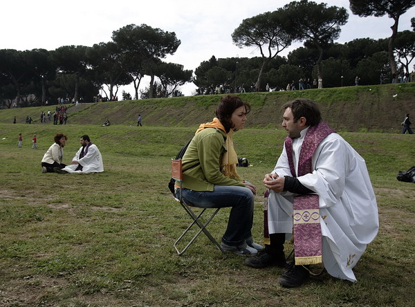 Priests listen to faithful's confessions at the Circo Massimo in Rome where people gathered to pray and look at the live broadcast on a giant videoscreen during the funeral of Pope John Paul II in St. Peter's Square at the Vatican, Friday April 8, 2005. Hundreds of thousands of mourners participated in the funeral either in St. Peter's square or via live broadcast on the many screens disseminated in the city of Rome and in many other locations all over the World. (AP Photo/Dusan Vranic)