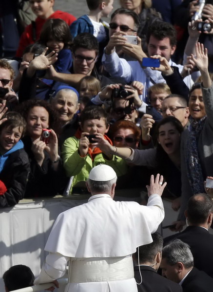 Pope Francis waves as he driven through the crowd during his general audience, in St. Peter's Square, at the Vatican, Wednesday, March 27, 2013. (AP Photo/Gregorio Borgia)