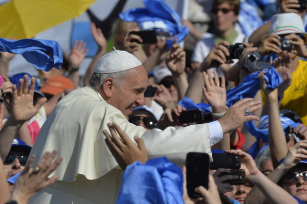 Pope Francis greets the crowd as he arrives for an audience with Catholic schools at St Peter's square on  May 10, 2014 at the Vatican.  AFP PHOTO / ANDREAS SOLARO
