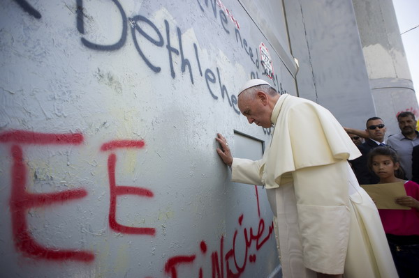 TOPSHOTS
A handout picture released by the Vatican press office shows Pope Francis praying at Israel's separation barrier on May 25, 2014 after he made an unscheduled stop at the security wall drawing attention to the towering eight-metre (26-foot) high concrete wall topped by a guard tower. Pope Francis arrived in Bethlehem to begin the most sensitive part of his three-day Middle East tour aimed at forging regional peace and easing an age-old rift within Christianit AFP PHOTO/ OSSERVATORE ROMANO / HO  == RESTRICTED TO EDITORIAL USE - MANDATORY CREDIT "AFP PHOTO / OSSERVATORE ROMANO" - NO MARKETING NO ADVERTISING CAMPAIGNS - DISTRIBUTED AS A SERVICE TO CLIENTS==