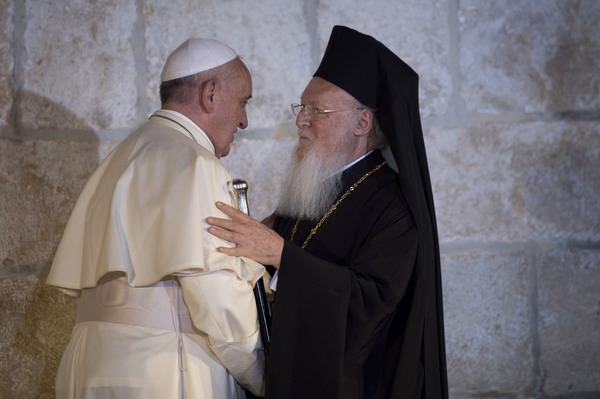 Pope Francis (L) greets Ecumenical Patriarch of Constantinople Bartholomew I outside the Church of the Holy Sepulchre in Jerusalem's Old City on May 25, 2014 during a meeting on the occasion of the historic rapprochement between both branches of the Christian church 50 years ago. They met at the Church of the Holy Sepulchre after signing a landmark pledge to work together to further unity between the eastern and western branches of Christianity, estranged for a millennium. AFP PHOTO / VINCENZO PINTO
