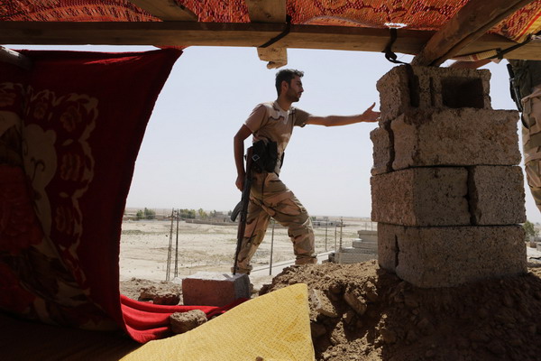 A Kurdish Peshmerga fighter stands guard at the Bakirta frontline near the town of Makhmur, south of Erbil, the capital of Iraqi Kurdistan August 27, 2014.  REUTERS/Youssef Boudlal (IRAQ - Tags: CIVIL UNREST POLITICS MILITARY) - RTR43ZGG