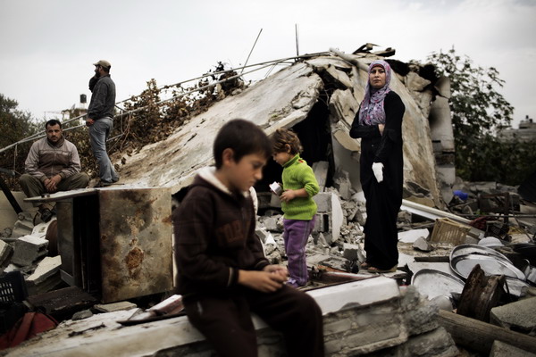 Members of the Palestinian al-Attar family, displaced during the eight-day conflict with Israel, return to their home in the al-Atatra area in the northern Gaza Strip November 22, 2012, a day after a ceasefire took hold in and around Gaza. A week of cross-border violence between Israel and Palestinian militants has killed at least 160 people. AFP PHOTO/MARCO LONGARI