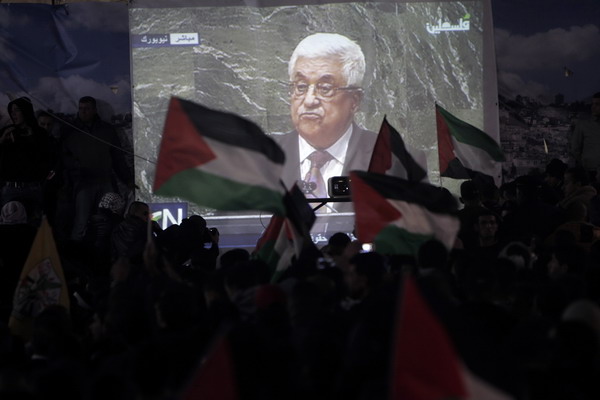 Palestinians watch on a giant screen Palestinian President Mahmoud Abbas speaking at the UN on November 29, 2012 in Ramallah. The UN General Assembly voted overwhelmingly to recognize Palestine as a non-member state, giving a major diplomatic triumph to president Mahmud Abbas despite fierce opposition from the United States and Israel. AFP PHOTO/AHMAD GHARABLI