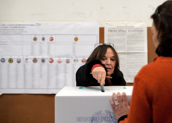 A woman casts her vote in a polling station in Rome on February 25, 2013 during Italy's general elections. Italians fed up with austerity voted in the country's most important election in a generation, as Europe held its breath for signs of fresh instability in the eurozone's third economy. AFP PHOTO/ Filippo MONTEFORTE