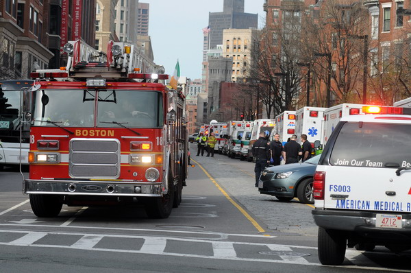 A long line of ambulances wait in a staging area after explosions rocked the finish area of the Boston Marathon on April 15, 2013 in Boston, Massachusetts.  At least two people were killed and 22 wounded when two explosions struck near the finish line of the Boston Marathon, sparking scenes of panic, police said. The streets were littered with debris and blood and paramedics raced off with stretchers as police locked down the area, witness said. TV footage showed an explosion sending up a white plume of smoke along the sidelines of the race.    AFP PHOTO/John MOTTERN