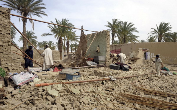 Pakistani earthquake survivors search for belongings in their collapsed mud houses in the Mashkail area of the southwestern Baluchistan province on April 17, 2013. Pakistani troops scrambled to aid the remote victims of an earthquake centred in nearby Iran, as the United States offered assistance and a strong aftershock jolted the region. The epicentre of the 7.8 magnitude quake on April 16, lay in southeast Iran but all 40 deaths reported so far have been across the border in Pakistan's dirt-poor province of Baluchistan, where hundreds of mud-built homes suffered damage.   AFP PHOTO/ BANARAS KHAN