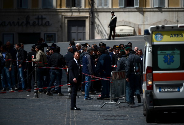Policemen stand near the area where a Carabiniere police officer was shot by an apparently disturbed man, on April 28, 2013 in Rome, outside the palazzo Chigi, the Italian Prime minister offices, while the country's new ministers were being sworn in. Two policemen were wounded, as well as a passerby, in the shooting. The attacker, named by Italian media as businessman Luigi Preiti, 49, was tackled to the ground by by police as witnesses fled the scene. AFP PHOTO / FILIPPO MONTEFORTE