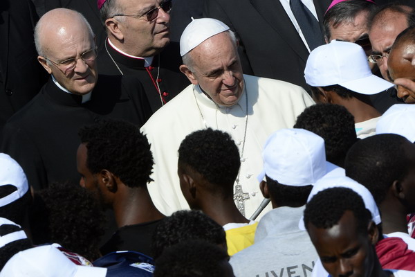 TOPSHOTS
Pope Francis (C) speaks to migrants during his visit to the island of Lampedusa, a key destination of tens of thousands of would-be immigrants from Africa, on July 8, 2013. Pope Francis called for an end to "indifference" to the plight of refugees on Monday on a visit to an Italian island where tens of thousands of migrants from Africa and the Middle East first reach Europe. AFP PHOTO / ANDREAS SOLARO