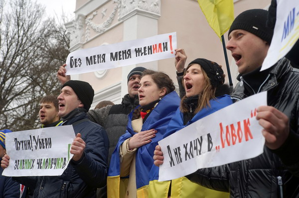 Pro-Ukrainian supporters hold banners reading "Putin take away the green man"(L)  and "I don't want Soviet" (R) during a rally at the monument of poet and national icon Taras Shevchenko the Crimean city of Simferopol on March 11, 2014. Ukraine's Crimea peninsula voted on March 11 for full independence from Ukraine in preparation for a referendum to join Russia while France threatened sanctions against Moscow as early as this week. AFP PHOTO/ GENYA SAVILOV
