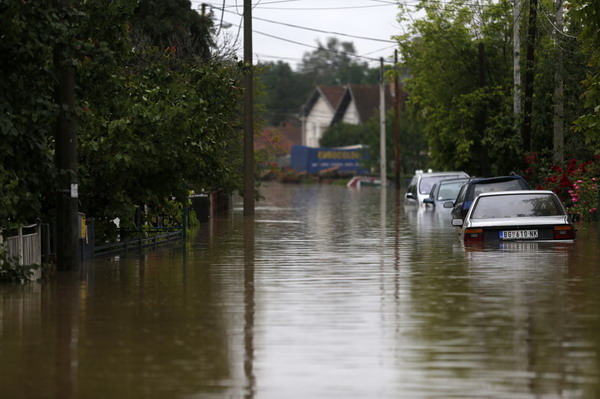 Cars are parked on a flooded street in Obrenovac, some 30 kilometers (18 miles) southwest of Belgrade, Serbia, Friday, May 16, 2014. Rain-swollen rivers across the Balkans have flooded roads, cut off power and caused more than 200 landslides. (AP Photo/Marko Drobnjakovic)