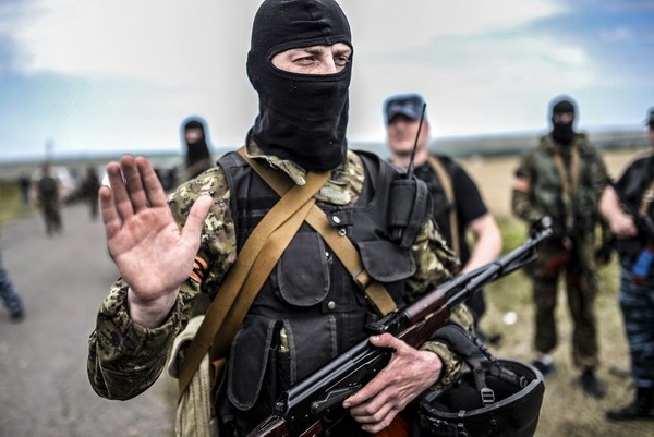 An armed pro-Russian separatists gestures as he blocks the way to the crash site of Malaysia Airlines Flight MH17, near the village of Grabove, in the region of Donetsk on July 20, 2014. The missile system used to shoot down a Malaysian airliner was handed to pro-Russian separatists in Ukraine by Moscow, the top US diplomat said Sunday. Outraged world leaders have demanded Russia's immediate cooperation in a prompt and independent probe into the shooting down on July 17 of flight MH17 with 298 people on board. AFP PHOTO/ BULENT KILIC