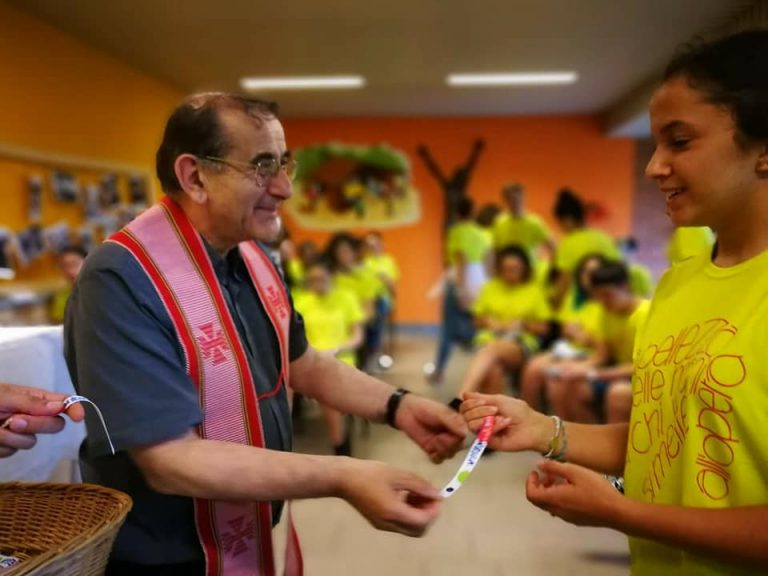 L'Arcivescovo consegna il braccialetto a un'animatrice dell'oratorio estivo