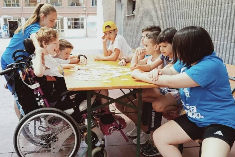 Un momento di svago all'oratorio di Bresso. Da notare le improvvisate zeppe al tavolo, fissate con lo scotch, per facilitare il gioco di chi è in carrozzina. L'integrazione aguzza l'ingegno dei ragazzi 