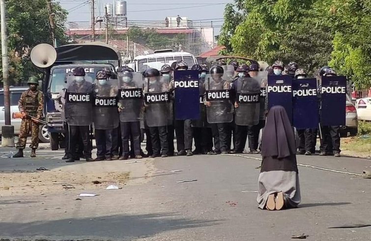 La religiosa in preghiera davanti alla polizia