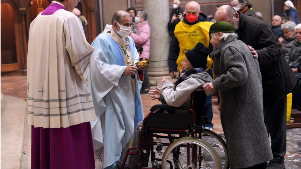 L'Arcivescovo distribuisce l'Eucarestia ai malati (foto Agenzia Fotogramma)