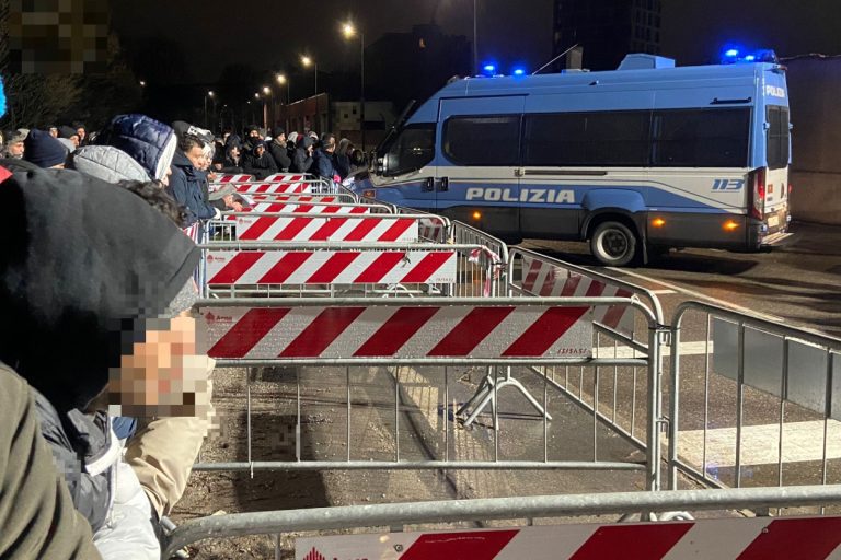 Alcuni richiedenti asilo in coda in via Cagni a Milano