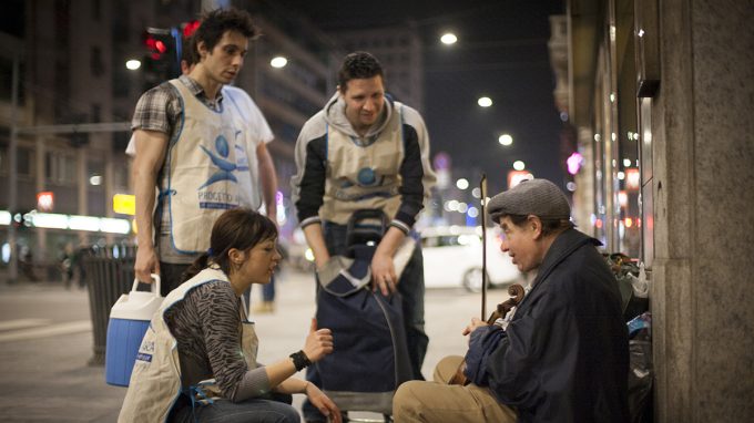 Una persona senza dimora soccorsa da alcuni volontari della fondazione arca a milano
