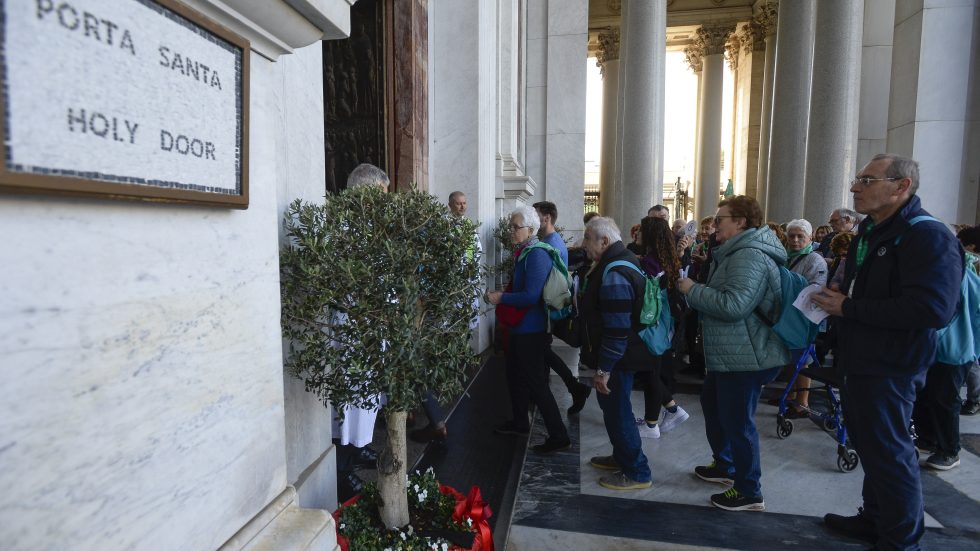 I fedeli entrano in San Paolo attraverso la Porta Santa (Agenzia Fotogramma)