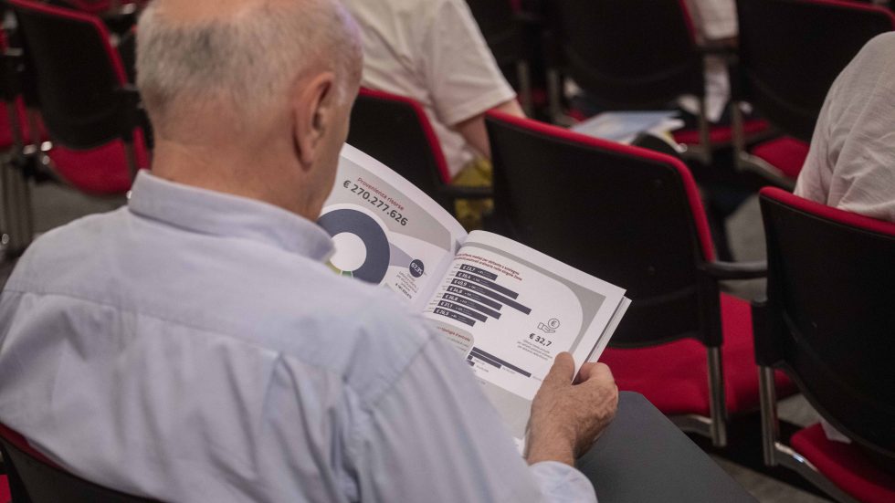 Un partecipante alla presentazione sfoglia il documento (Agenzia Fotogramma)