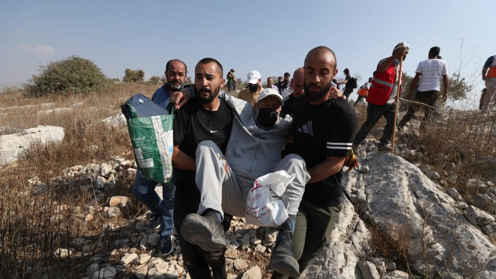 Palestinesi soccorrono un ferito durante alcuni scontri con le truppe israeliane (Foto ANSA/SIR)