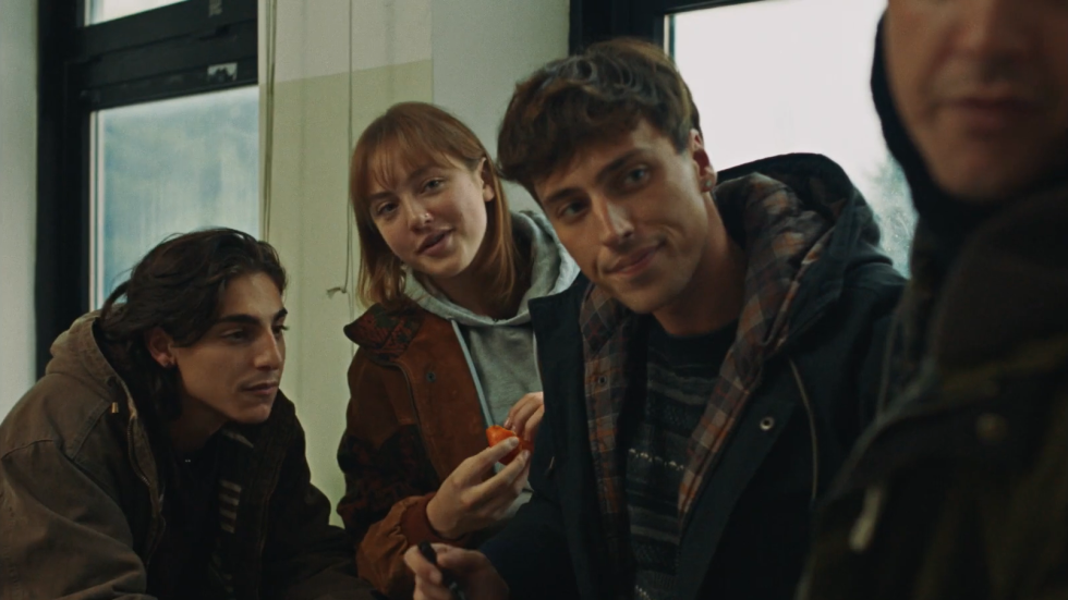 Quattro studenti seduti insieme in classe osservano qualcosa fuori campo in una scena del film Un anno di scuola